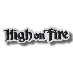 May include: Embroidered patch with the words "High on Fire" in black script lettering. The patch has a white border and is set against a white background. The text is in a stylized font.