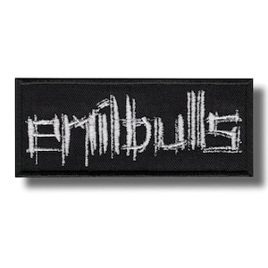 Puede incluir: Parche rectangular negro con la palabra "Eriibulls" bordada en blanco, con una fuente estilizada y desgastada. El parche tiene un borde negro y probablemente está hecho de tela. El texto parece ser el nombre de una banda o marca.