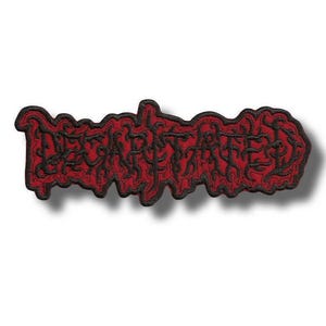 May include: A red and black embroidered patch featuring the word "DECARNATED" in a stylized, gothic font. The patch has a black border and a shadow effect, giving it a three-dimensional appearance. The text is in a bold, heavy metal style.