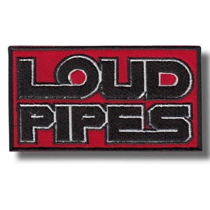 May include: Embroidered patch featuring the text "LOUD PIPES" in black, outlined in white, on a red rectangular background. The patch has a black border. This patch is designed to be sewn onto clothing or accessories, adding a bold statement.