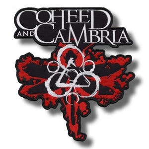 May include: Embroidered patch featuring the band name "Coheed and Cambria" in white lettering on a black background. The patch has a red and black design with a white emblem in the center. The patch is likely for a jacket or bag.