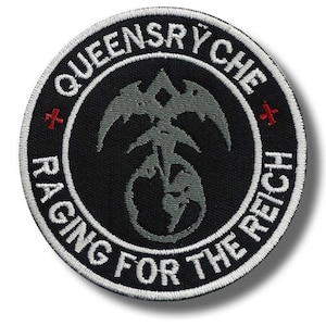 May include: A round, black embroidered patch with white text and a gray emblem. The text reads "QUEENSRYCHE" and "RAGING FOR THE REICH". Two red crosses are on either side of the emblem. The emblem is a stylized design.