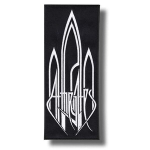 Op de afbeelding: Zwart rechthoekig embleem met witte gestileerde tekst en een centraal ontwerp dat lijkt op een gestileerde boog. De tekst luidt "ATHAZAHS" in een gotisch lettertype. Het embleem is waarschijnlijk gemaakt van stof en geschikt om op kleding of accessoires te naaien of te strijken.