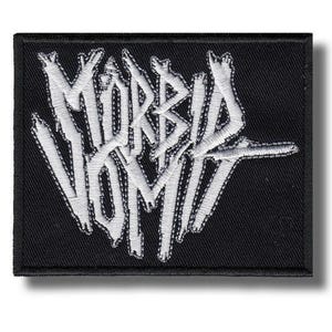 以下が含まれることがあります： 黒い長方形のパッチ。白い刺繍で「MORBID VOMIT」と書かれた、様式化されたゴシック体の文字。パッチには黒い縁取りがあり、衣類やアクセサリー用です。