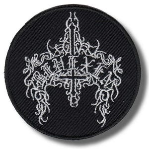 Könnte beinhalten: Runder schwarzer Aufnäher mit weißem Stickdesign. Das Design zeigt ein zentrales Kreuz mit verschnörkelten Mustern und Text. Geeignet für Kleidung oder Accessoires.