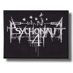 Könnte beinhalten: Schwarzer rechteckiger Aufnäher mit dem weißen Text "PSYCHONAUT 4" in einer stilisierten, gotischen Schrift. Das Design umfasst abstrakte Formen und Linien mit einem tropfenden Effekt. Der Aufnäher ist wahrscheinlich für Kleidung oder Accessoires.
