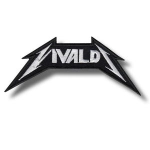 May include: A black and white embroidered patch with the word "VALD" in white, stylized text. The patch has a unique, angular shape with pointed edges, and is likely designed for application on clothing or accessories.