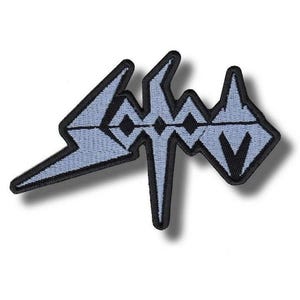 Pode incluir: Patch bordado com a palavra "SODOM" em azul claro, com contorno preto. O design inclui um raio e formas geométricas. Perfeito para personalizar roupas ou acessórios.