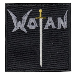 Può includere: Toppa quadrata nera con la scritta "WOTAN" in grigio e una spada bianca con elsa dorata. La toppa ha un bordo cucito.