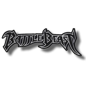 May include: A black and white embroidered patch featuring the band name "BATTLE BEAST" in a stylized, gothic font. The patch has a black background with white outlining, creating a bold contrast. The design is symmetrical and elongated.