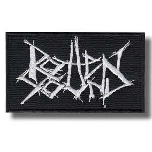 Puede incluir: Parche rectangular negro con texto blanco bordado. El texto parece ser un logotipo de banda estilizado. El parche tiene un borde negro y probablemente está hecho de tela. El diseño es audaz y gráfico.