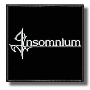 Può includere: Toppa quadrata nera con la scritta "Insomnium" ricamata in bianco. La parola è stilizzata con un ornamento decorativo sul lato sinistro. La toppa ha un bordo nero.