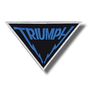 Könnte beinhalten: Ein schwarzer, dreieckiger Aufnäher mit dem Wort "TRIUMPH" in blauer Stickerei. Der Aufnäher hat einen weißen Rand und blaue Blitzdesigns. Er ist wahrscheinlich für einen Motorrad- oder Automobil-Enthusiasten gedacht.
