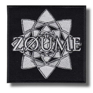 Può includere: Toppa quadrata nera con design geometrico bianco ricamato e la parola "ZØUME". Il design presenta una forma a stella composta da triangoli interconnessi. La toppa ha un bordo nero ed è probabilmente una toppa da stirare o da cucire.