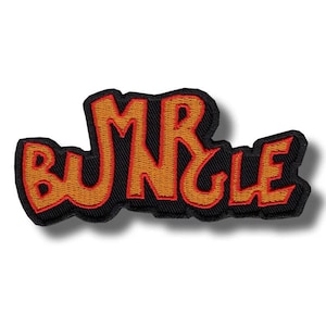 Puede incluir: Parche bordado con la inscripción "MR BUNGLE" en naranja, contorneada en rojo, sobre fondo negro. El parche tiene una forma ligeramente irregular y un efecto de sombra. Ideal para chaquetas, bolsos u otros artículos textiles.