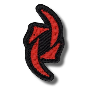 May include: Embroidered patch featuring a stylized red arrow design on a black background. The patch has a black border and is likely designed to be ironed or sewn onto fabric. The arrow design is a bold, eye-catching element.