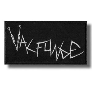 Peut inclure: Écusson rectangulaire noir avec texte brodé blanc « VALFLAKE ». Le patch présente un design audacieux, avec une police de style manuscrit. Il est probablement destiné aux vêtements ou aux accessoires.