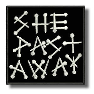Peut inclure: Écusson carré noir avec l'inscription brodée en blanc « SHE ATE AWAY ». Les lettres sont formées de clous, créant un design texturé. Le patch est bordé d'un liseré noir.
