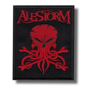 May include: Black embroidered patch featuring the band name "ALESTORM" in red script above a red skull with tentacles and crossed bones. The patch is rectangular and has a black border.