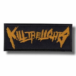 Op de afbeelding: Zwart rechthoekig embleem met de woorden "KILL THE LIGHTS" geborduurd in goud. De tekst heeft een verweerde, grillige letterstijl. Geschikt voor het personaliseren van kleding.