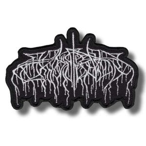 May include: Black embroidered patch with white gothic lettering and a dripping effect. The patch features a stylized design with a central vertical element and intricate, flowing lines. The patch is likely for clothing or accessories.