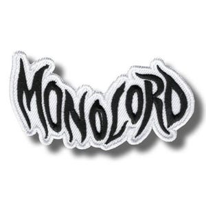 Könnte beinhalten: Gestickter Aufnäher mit dem Wort "MONOLORD" in schwarzer, stilisierter Schrift. Der Aufnäher hat einen weißen Rand und einen leichten Schatteneffekt, der ihm ein erhabenes Aussehen verleiht. Das Design befindet sich auf weißem Hintergrund.