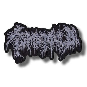 May include: Black embroidered patch with the word "SOMETHING" in a stylized, gothic font. The text is in a light grey color, with a dripping effect. The patch has a black border.