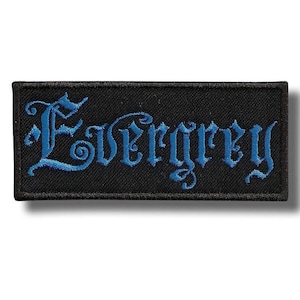 May include: Black rectangular patch with the word "Evergrey" embroidered in blue gothic lettering. The patch has a black border and is likely made of fabric.