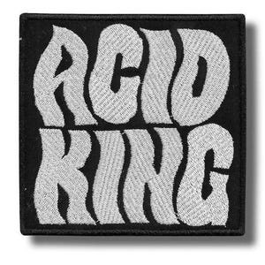 May include: Square black patch with white embroidered text that reads "ACID KING" in a bold, wavy font. The patch has a black border and is likely designed to be sewn or ironed onto clothing or accessories.