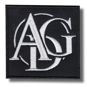 May include: Square black patch with white embroidered letters "AG" inside a circle. The patch has a black border and a shadow effect, creating a 3D appearance. The letters are in a stylized, elegant font.