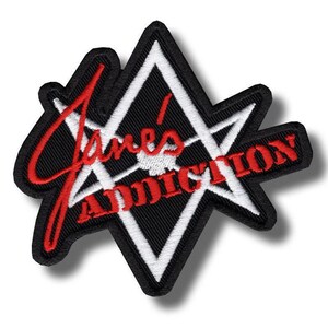 May include: Embroidered patch with the words "Jane's Addiction" in red script over a black and white geometric design. The patch has a black border. The patch is likely for a jacket or bag.