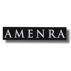 May include: Black rectangular patch with the word "AMEN RA" embroidered in white capital letters. The patch has a simple, clean design, with the text centered on the black background. The patch is likely for clothing or accessories.
