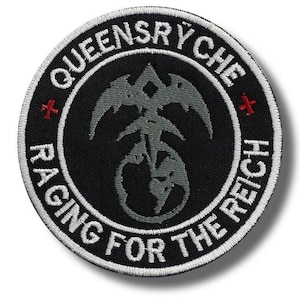 May include: A circular black patch with white embroidered text and a gray emblem. The text reads "QUEENSRYCHE" at the top and "RAGING FOR THE REICH" at the bottom. Two red crosses flank the emblem.
