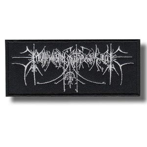 Puede incluir: Parche rectangular negro con texto blanco estilizado. El texto, probablemente un nombre de banda o logotipo, presenta letras góticas intrincadas. El parche es de tela y está diseñado para coserse o plancharse en ropa o accesorios.