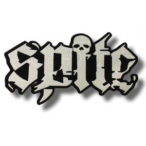 Könnte beinhalten: Ein schwarz-weißer Aufnäher mit dem Wort "SUICIDE" in gotischer Schrift. Der Aufnäher zeigt einen Totenkopf in der Mitte des Wortes. Der Aufnäher ist rechteckig mit einem schwarzen Rand und einem weißen Hintergrund.