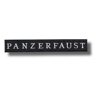 May include: A black rectangular patch featuring the word "PANZERFAUST" embroidered in white capital letters. The patch is likely made of fabric and has a simple, clean design.