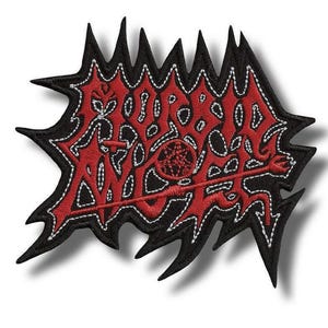 Peut inclure: Écusson brodé avec une bordure noire dentelée et un motif rouge. Le motif présente des lettres stylisées et un emblème central, le tout souligné de coutures blanches. L'écusson est probablement destiné aux vêtements ou aux accessoires.