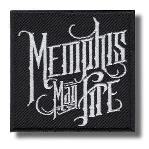 Op de afbeelding: Zwart vierkantige patch met witte geborduurde tekst die "Memphis May Fire" leest in een gestileerd lettertype. De patch heeft een zwarte rand en een schaduweffect.