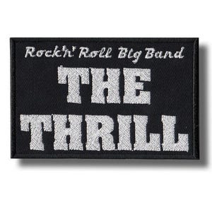 Può includere: Toppa rettangolare nera con testo ricamato bianco. Il testo recita "Rockin' Roll Big Band" sopra "THE THRILL". La toppa ha un bordo nero e un'ombra bianca.