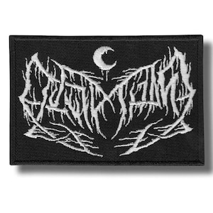 Puede incluir: Parche rectangular negro con texto bordado en blanco y una luna creciente. El texto es un logotipo de banda en una fuente gótica. El parche está diseñado para coserse en ropa o accesorios.