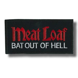 Może przedstawiać: Czarna, prostokątna naszywka z napisem "Meat Loaf" w kolorze czerwonym, stylizowaną czcionką, nad napisem "BAT OUT OF HELL" w kolorze białym. Naszywka ma czarną obwódkę i jest przeznaczona na odzież lub akcesoria.
