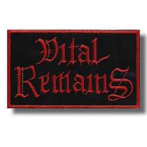 Op de afbeelding: Een zwart rechthoekig embleem met een rode rand en de woorden "Vital Remains" geborduurd in rode gotische letters. De patch is waarschijnlijk voor kleding of accessoires.