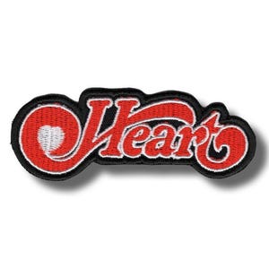 Op de afbeelding: Geborduurde patch met het woord "Heart" in rood script, witte omlijning en zwarte rand. Het ontwerp bevat een hartvorm in de letter "H".