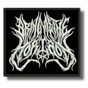 Peut inclure: Écusson brodé carré avec le texte blanc "BEHEMOTH" dans une police gothique stylisée, avec un pentagramme. L'écusson a un fond noir et une bordure noire.