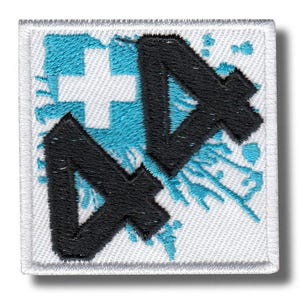 Peut inclure: Écusson carré brodé avec une bordure blanche. Le motif présente une croix blanche, des éclaboussures turquoise et les lettres stylisées noires "NA". L'écusson est sur fond blanc.