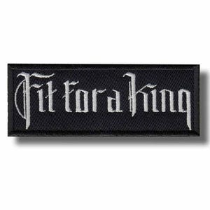 Può includere: Toppa rettangolare nera con la scritta ricamata "Fit for a King" in lettere gotiche bianche. La toppa ha un bordo nero ed è progettata per essere cucita o stirata su abiti o accessori.