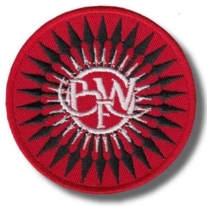 Könnte beinhalten: Ein runder, roter Aufnäher mit einem weißen und schwarzen Design. Der Aufnäher zeigt ein weißes Emblem mit den Buchstaben "BW" und "F" in einem weißen Kreis, umgeben von schwarzen pfeilartigen Formen, die nach außen strahlen. Der Hintergrund ist rot.