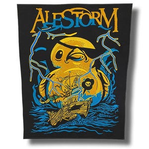 Peut inclure: Écusson noir avec le texte "ALESTORM" en jaune et bleu. L'écusson représente un canard jaune avec un cache-œil, un navire et des éclairs bleus. Une tête de mort et des os croisés sont dans une bulle.