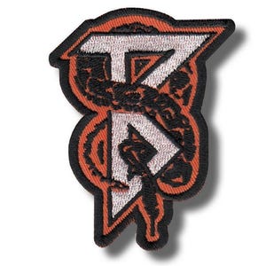 May include: Embroidered patch with a stylized design. The patch features the letters "T" and "R" in white, outlined in black and orange. The design includes a snake-like pattern and a black border.