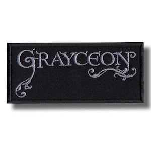 May include: Black rectangular patch with the word "GRAYCEON" embroidered in a stylized, light gray font. The patch has a decorative flourish on the left and right sides.